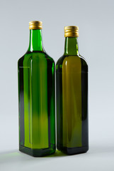 Bottles of cooking oil on light background