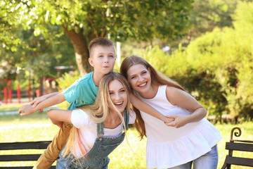 Lesbian mothers with foster son having fun in park