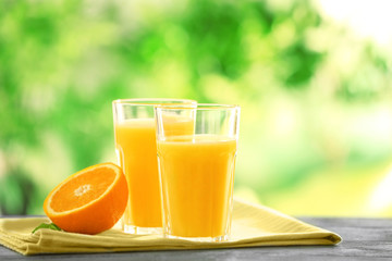 Glasses with delicious orange juice on table