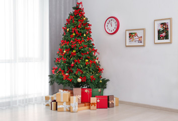 Beautiful Christmas tree with gifts in room