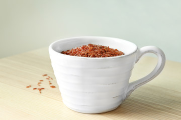 Cup with jasmine brown rice on table