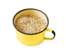 Enamel cup of long grain brown rice on white background