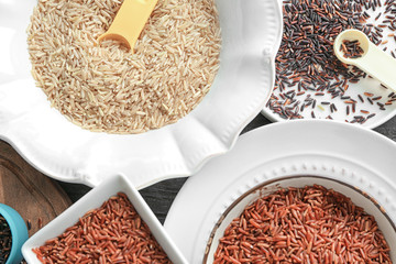 Different types of rice in bowls and plates on table