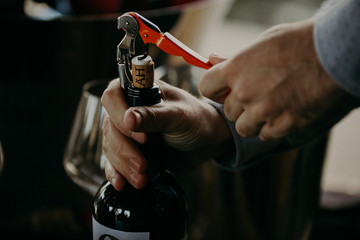 Sommelier opening wine bottle in the wine cellar - obrazy, fototapety, plakaty