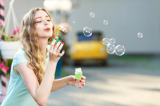 happy woman blowing soap bubbles 