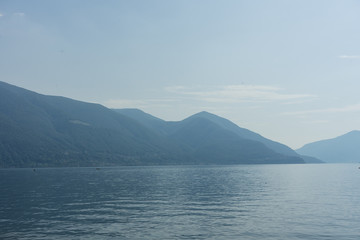 Fototapeta na wymiar Lago Maggiore Lake with fog and Mountain landscape in Ascona Switzerland
