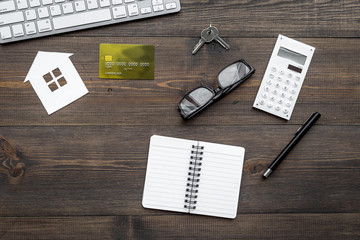 purchasing house with online payment on work desk wooden background top view mock up