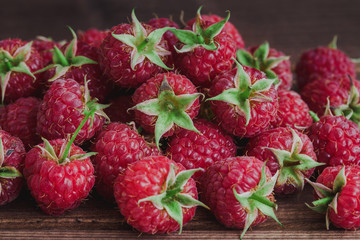 Pink tasty raspberries on wooden desk table.