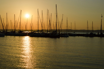 Amazing sunset on the Balaton Lake (Hungary) with sailboats in the harbor