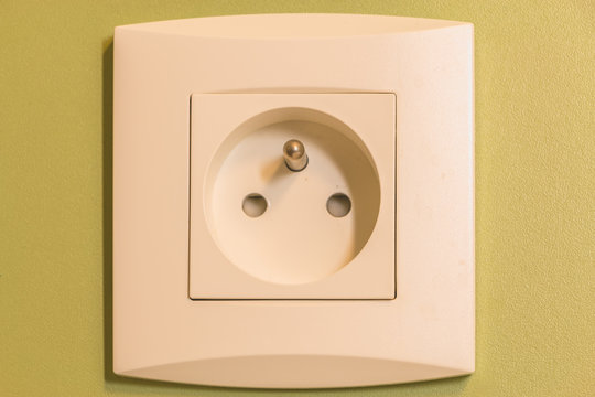residential wall socket on a green wall