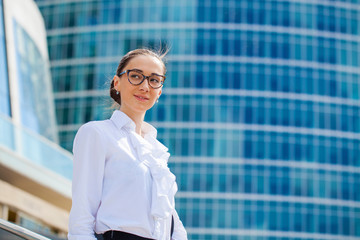 Young business woman on the background of skyscrapers