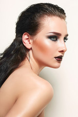 Obraz premium Beautiful young girl with wet hair and bright make-up in studio on a white background. Portrait.