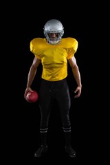 Fototapeta premium American football player holding a ball in one hand