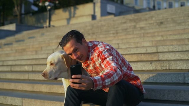 Boy with labrador dog make selfie cellphone cityscape sundown rapid slow motion