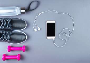 Flat lay shot of sneakers, earphones, phone.