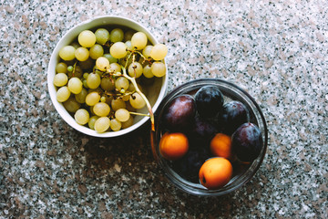 Grapefruit and plums on marble