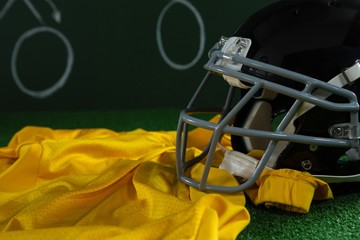 American football jersey and head gear lying on artificial turf