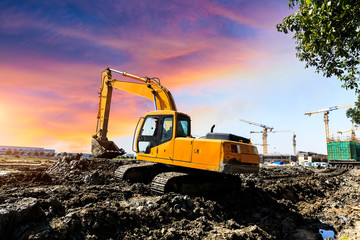 Obraz premium Excavator working at construction site on sunset