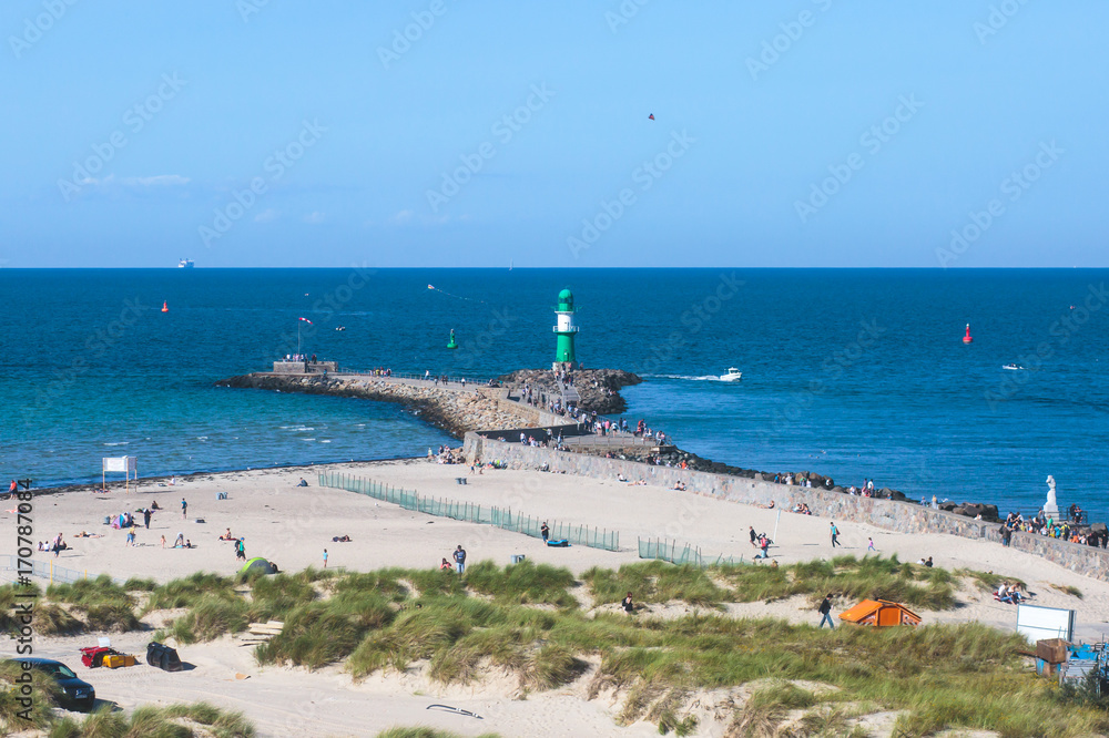 Wall mural Beautiful summer vibrant view of Warnemunde, Rostock, Germany, popular german seaside resort, with beach, seashore and lighthouse