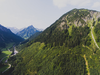 View of bavarian alpine village with a valley and mountains, shot from drone, Bayern, Bavaria, Germany, sunny summer day