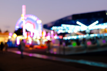 Abstract blur lights of ferris wheel and other attractions at night