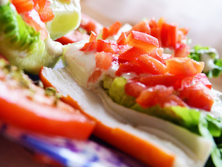 Natural organic salad served on a blue plate on a white wooden table. Macro and selective focus.