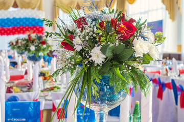 Fototapeta na wymiar beautiful colorful flower bouquets in glass vases on tables