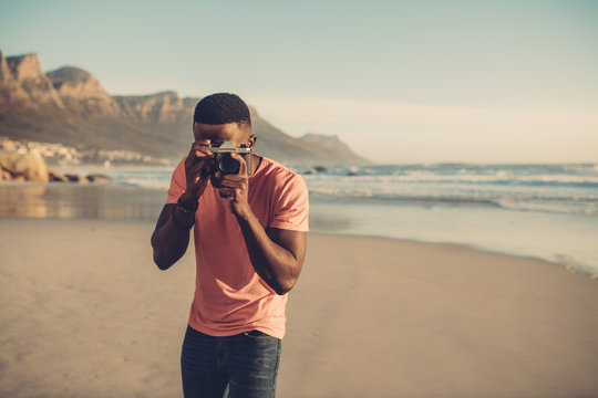 Man taking photos with digital camera at beach