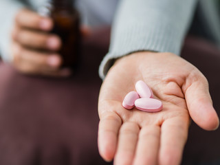 Closeup woman hand holding a pill. Healthcare, medical supplements concept