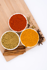 Herbs and spices such as star anise, cinnamon, turmeric, chilli powders and other on a chopping board