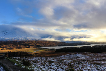 Incredible cloudscape during sunset in the Scottish Highlands with sun glowing through the clouds.