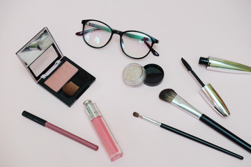 Make-up brushes, glasses, blush, nude lipstick, maskara. Autumn the trend of fashion. Ladies fashion accessories.