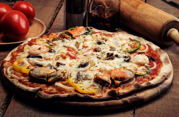 Delicious seafood pizza served on wooden table