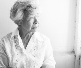 Side view of elderly asian woman with thoughtful face expression