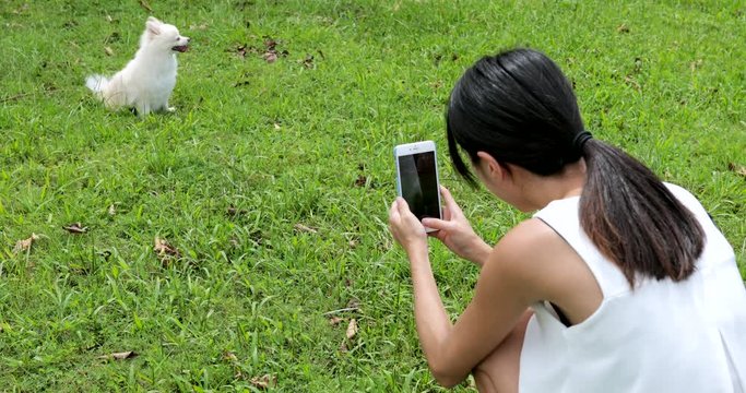 Woman taking photo with cellphone on her dog