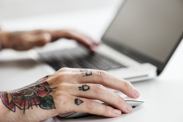 Hand with tattoo holding using mouse
