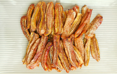 sun dried bananas (honey baked bananas) on plate isolated on white background, Thai preserved food.