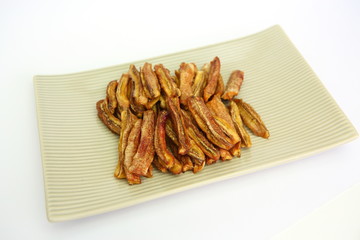 sun dried bananas (honey baked bananas) on plate isolated on white background, Thai preserved food.