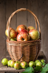 Fresh ripe apples in basket on rustic  table