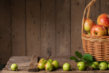 Fresh ripe apples in basket on vintage wood table