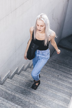Young cool woman in the city at sunset