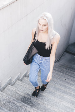 Young cool woman in the city at sunset