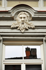 Fototapeta premium Decorative sculpture of the old man's head above the window. Vilnius, Lithuania.