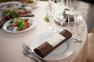 Table setting in the restaurant. Guest card and napkin