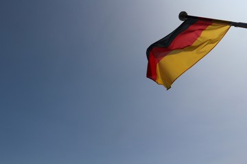 German flag in the wind against blue sky