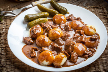 Stew served with silesian noodles and sauce.