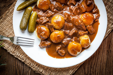 Stew served with silesian noodles and sauce.