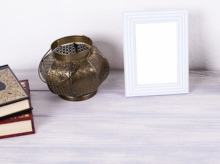 Photo frames next to decorative objects and books on white and blue wood table. Decor.