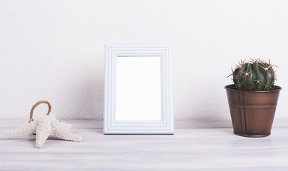 Photo frame with heart shape next to decoration objects on white and blue wooden table. Decor.