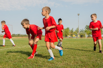 Kids soccer football - children players exercising before match on soccer field